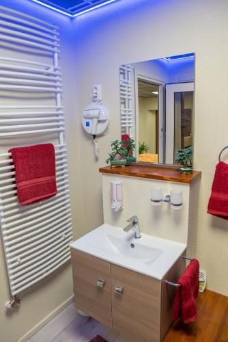 a bathroom with a sink and a mirror at E14 apartman in Berekfürdő
