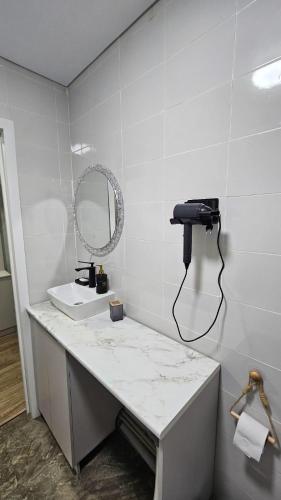 a bathroom with a sink and a phone on a counter at 1 комнатные апартаменты 4а 67 in Semey
