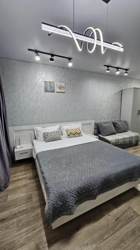 a bedroom with a large bed and a couch at 1 комнатные апартаменты 4а 67 in Semey