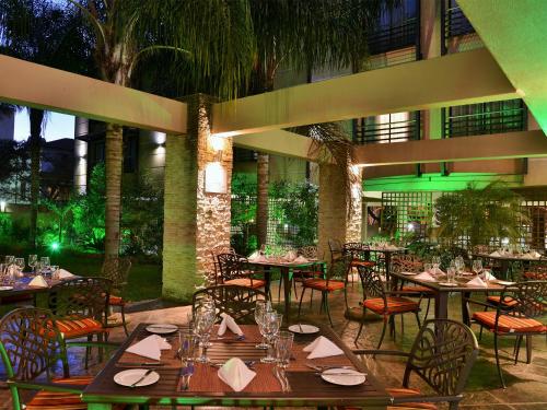 un restaurant avec des tables et des chaises dans une cour dans l'établissement Premier Hotel Pretoria, à Pretoria