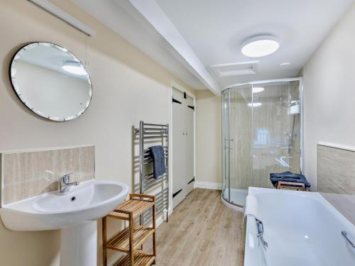 a bathroom with a sink and a tub and a mirror at 1 Bed in Alnwick oc-95776 in Chillingham