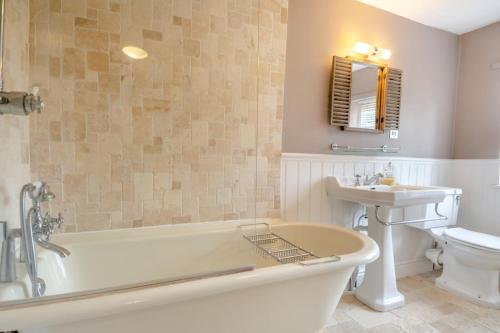 a bathroom with a tub and a sink and a toilet at 5 Bed in Bramfield oc-sftmh in Bramfield