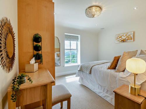a bedroom with a bed and a table with a chair at 5 Bed in Otley oc-95414 in Fewston