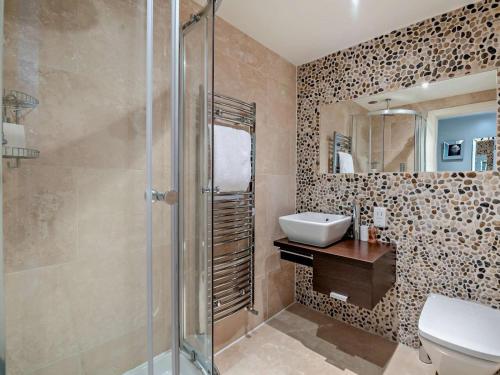 a bathroom with a shower and a sink and a toilet at 5 Bed in Otley oc-95414 in Fewston