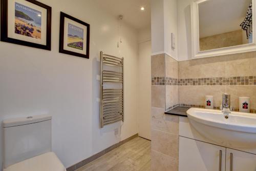 a bathroom with a white sink and a toilet at 3 Bed in Braunton oc-salar in Georgeham