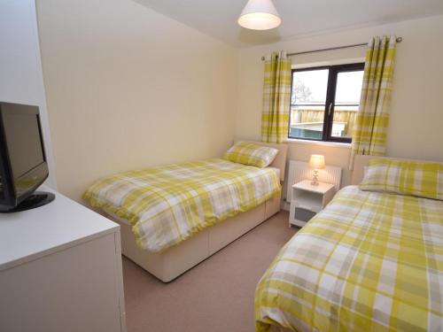 a bedroom with two beds and a tv and a window at 2 Bed in Chew Magna oc-chela in Stowey