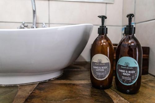 two bottles of soap sitting next to a sink at Cheetah View Lodge at Cheetah Conservation Fund in Otjiwarongo