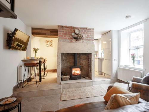 a living room with a fireplace and a table at 2 Bed in Morpeth oc-82238 in Rothbury