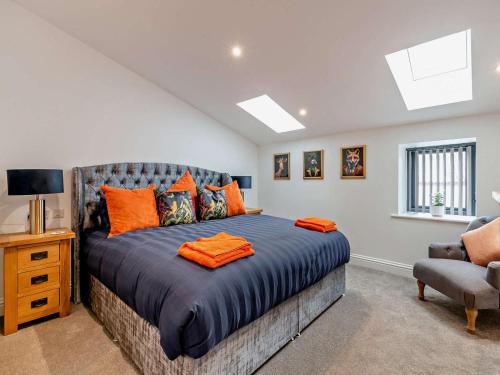 a bedroom with a large bed with orange pillows at 3 Bed in York oc-93897 in Tollerton