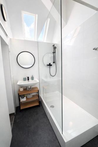a white bathroom with a shower and a sink at Gästehaus Kühnle in Bad Wildbad