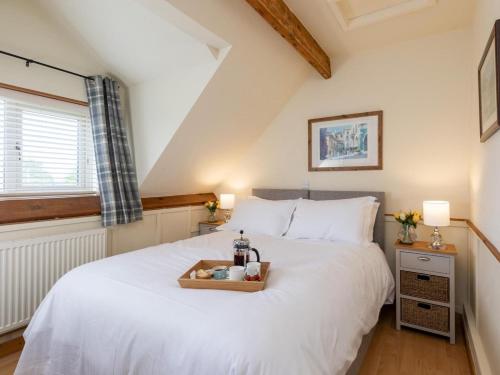 a bedroom with a white bed with a tray on it at 5 Bed in York oc-77267 in Green Hammerton