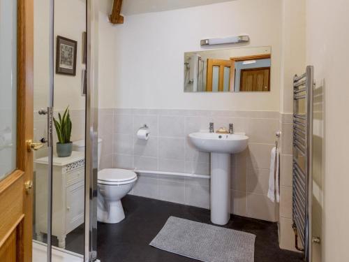 a bathroom with a sink and a toilet and a mirror at 5 Bed in York oc-77267 in Green Hammerton