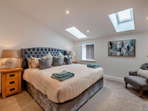 a bedroom with a large bed and a chair at 3 Bed in York oc-93898 in Tollerton