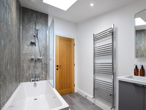 a bathroom with a tub and a shower and a sink at 3 Bed in York oc-93896 in Tollerton