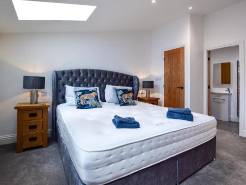 a bedroom with a large white bed with blue pillows at 3 Bed in York oc-93896 in Tollerton