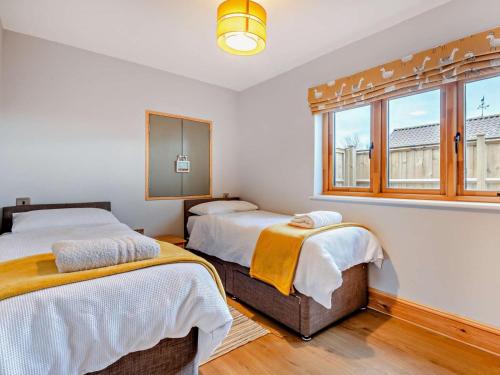 a bedroom with two beds and a window at 2 Bed in Axbridge oc-91358 in Loxton