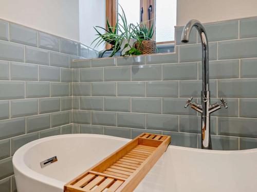 a bathroom with a bath tub with a faucet at 2 Bed in Axbridge oc-91358 in Loxton