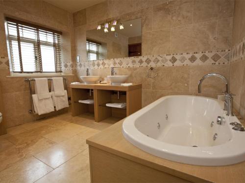 a large bathroom with a tub and two sinks at 4 Bed in Slingsby oc-g0146 in Hovingham