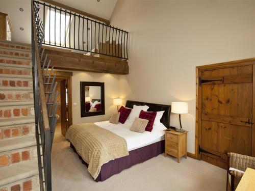 a bedroom with a large bed and a staircase at 4 Bed in Slingsby oc-g0146 in Hovingham