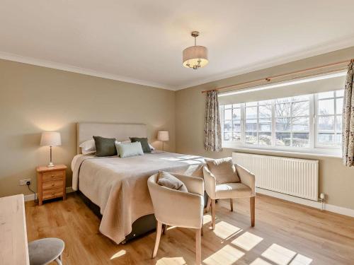 a bedroom with a bed and a table and chairs at 3 Bed in Thirsk oc-91245 in Sessay