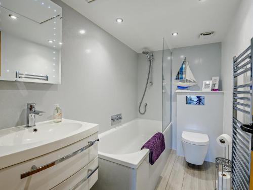 a bathroom with a sink and a tub and a toilet at 4 Bed in Lymington oc-nfl94 in Sway