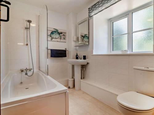 a bathroom with a tub and a toilet and a sink at 3 Bed in Dorchester oc-92414 in Frome Vauchurch