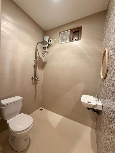 a bathroom with a toilet and a sink at AMIGOS Hostel El Nido in El Nido