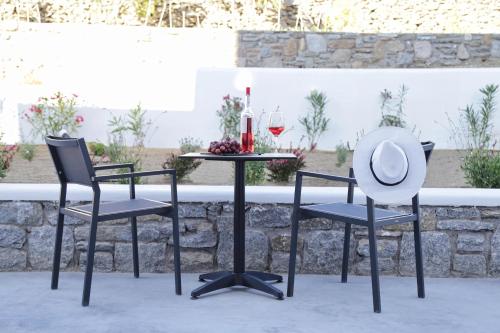 two chairs and a table with a hat on it at Livin Mykonos Hotel - Adults Only by Mr and Mrs White in Mikonos