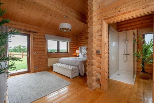a bedroom in a log cabin with a bed and a shower at Penhill in Constable Burton