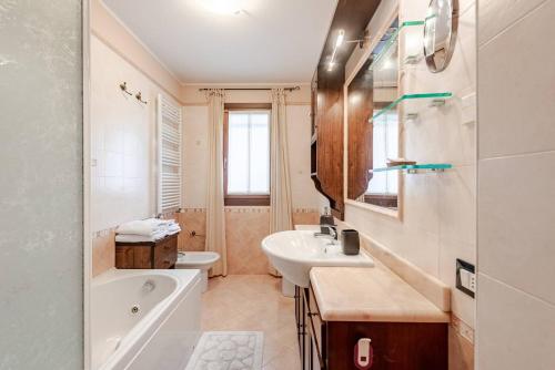 a bathroom with a sink and a tub and a toilet at La tua casa meravigliosa con giardino in Fontanafredda