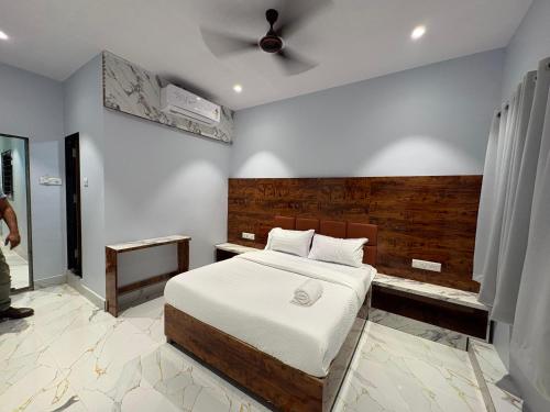 a bedroom with a bed and a ceiling fan at Hotel Midnight Lodging & Boarding in Panvel