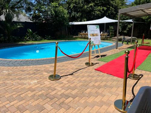 a swimming pool with a red carpet and a red rug at OGL Guesthouse in Vanderbijlpark