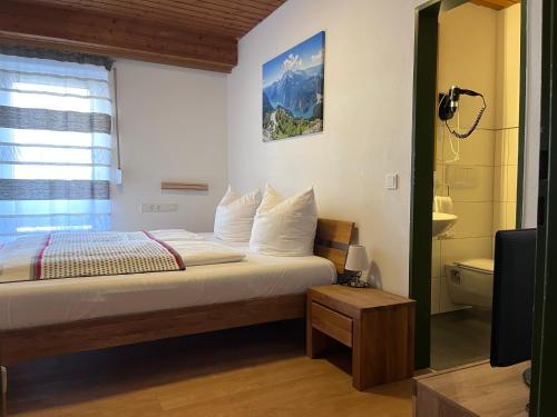 a bedroom with a bed with a window and a television at Ferienwohnung zum Breu im Löwen in Reit im Winkl