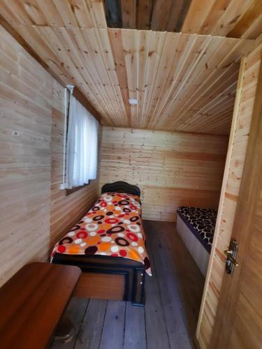 a small room with a bed in a wooden cabin at Dartlo Hotel in Dart'lo