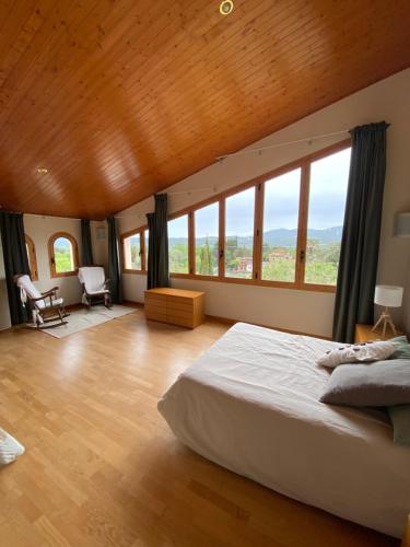 a bedroom with a large bed and large windows at Can Catrol in Santa Cristina d'Aro
