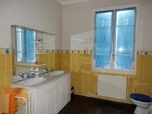 a bathroom with two sinks and a window at Chambres d'Hôtes La Maison Blanche in Lorp Sentaraille