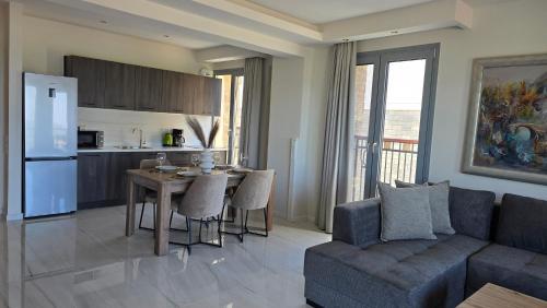 a living room with a couch and a table and a kitchen at Panorama Serenity Suites in Thessaloniki