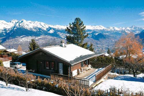 a house in the snow with mountains in the background at Les Cassis in Nendaz