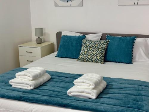 a bed with three towels on a blue blanket at Cantinho dos Sonhos in Santa Cruz