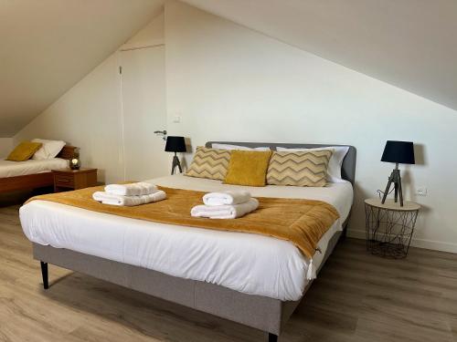 a bedroom with a large bed with towels on it at Cantinho dos Sonhos in Santa Cruz