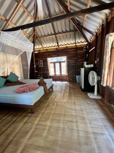 a room with two beds and a fan in it at Kwangpeeb Homestay in Ko Phayam