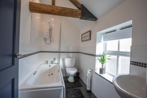 a bathroom with a tub and a toilet and a sink at The Old Mill - Ripon Centre in Ripon