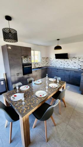a dining room with a table and chairs in a kitchen at Gîte cosy près de la mer - Maison familial tout équipé - Côte d'Albâtre in Cany-Barville