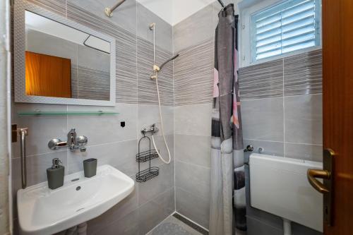 a bathroom with a sink and a shower at Apartmani Tinka in Starigrad
