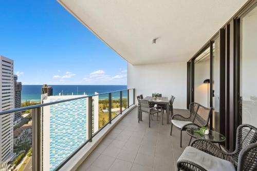a balcony with a table and chairs and a view of the ocean at Ocean View 3-Bed with Gym, Pool, Sauna & Parking in Gold Coast