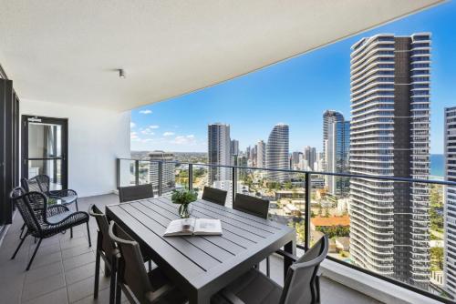 a dining room with a large balcony with a table and chairs at Ocean View 3-Bed with Gym, Pool, Sauna & Parking in Gold Coast