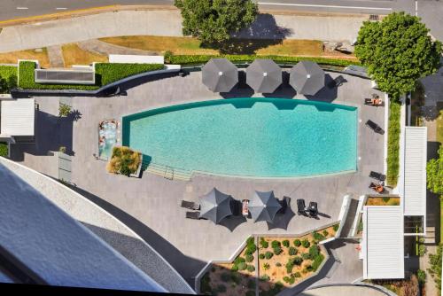 an overhead view of a swimming pool with umbrellas at Ocean View 3-Bed with Gym, Pool, Sauna & Parking in Gold Coast