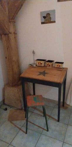 a wooden table with a chair in a room at Gite de la Jument grise-calme et tranquillité in Lescheroux