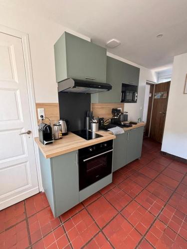 a kitchen with a stove and a counter top at Séjour idyllique normand - Appartement cosy à 5 min de la plage - Veules-les-Roses in Veules-les-Roses