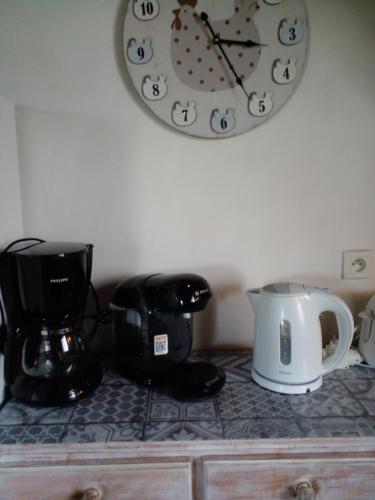 a clock on the wall above a coffee maker and a blender at Gite de la Jument grise-calme et tranquillité in Lescheroux